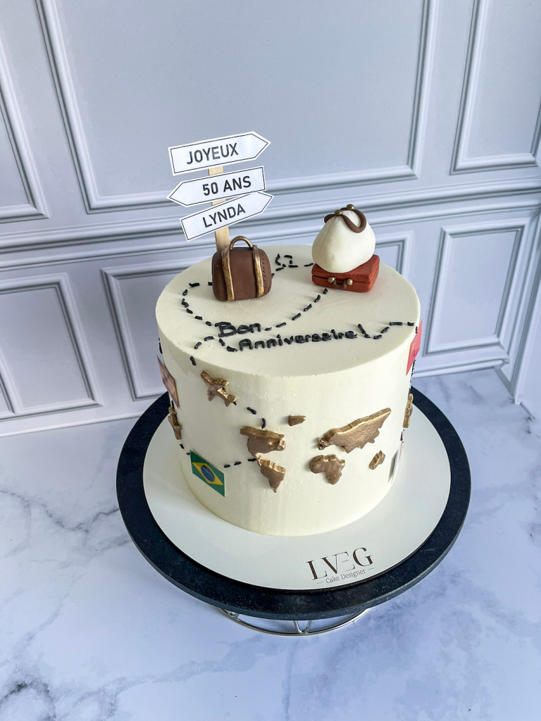 Cake Design sur le thème du voyage à travers le monde décoré des continents et de valises en pâte à sucre